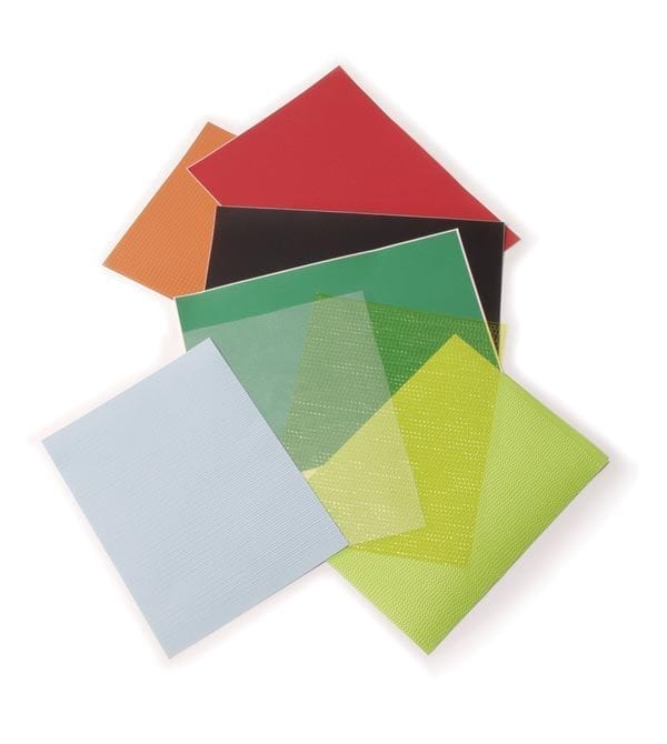 A stack of multi-colored textured paper spread across on a white surface.