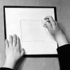 A black and white photo shot on film of two hands using the Swail Dot Inverter to create a tactile square.