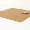 The light brown Swail Dot Inverter pad sitting on a white background with the silver metal stylus sitting on top.