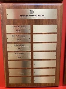Plaque displaying recipients of the Wings of Freedom Award from 2014-2018 in print and braille