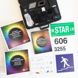 Envision Kit with Optical Aids opened to show training curriculum, activity cards, signage, and the carrying case which houses optical arrays