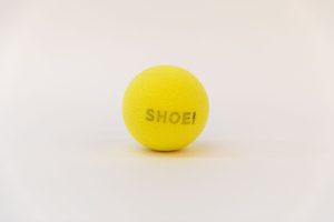 A yellow tennis ball with the word