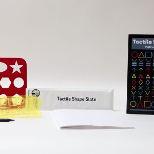 All the components of the Tactile Shape Slate kit, including a yellow slate, a large red stencil, and the guidebook, all laid out on a white background.