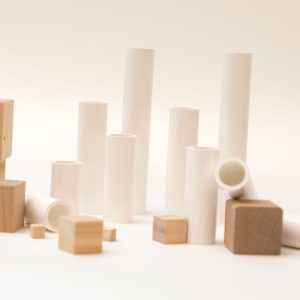 An assortment of white plastic cylinders and wooden cubes in varying sizes
