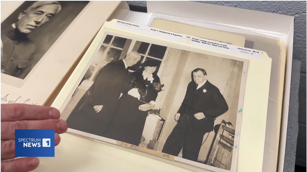 A screengrab of the news story. There is a photo of Helen Keller standing with two men. The photograph is black and white.