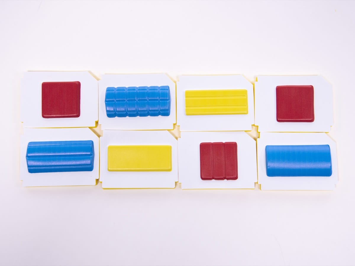 A collection of rectangles, squares, and circles each in bright shades of red, yellow, and blue lay on a table.