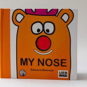 My Nose front cover on a white background. The main character is orange with a pink hat and a red nose. The book says "My Nose" with an APH logo in the bottom left corner and a UEB logo in the bottom right.