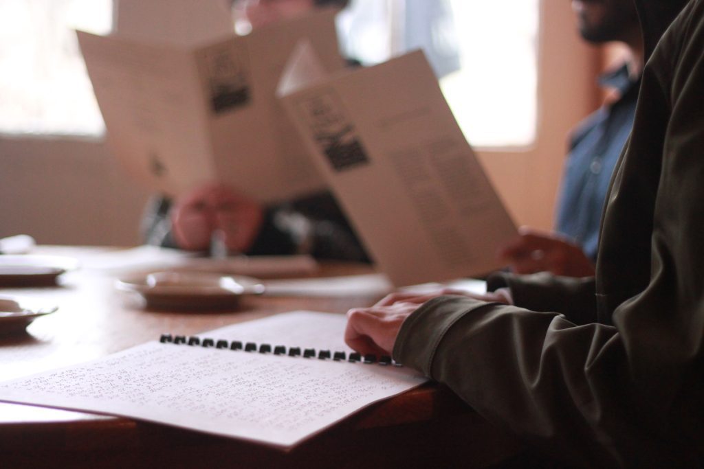 Close up of hands reading a braille menu