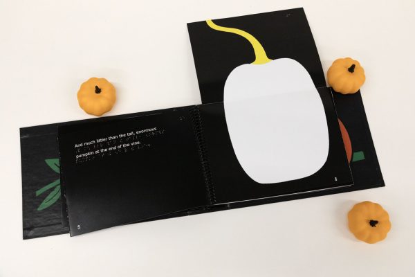 The book is open to a page that folds out vertically to display a large white pumpkin. 