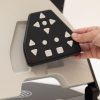 A woman's hand is returning the black Neptune keypad into the recess on the back of the device where a magnet holds it in place.