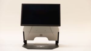 The opened Neptune device with a monitor attached. On the black base is a white APH logo.