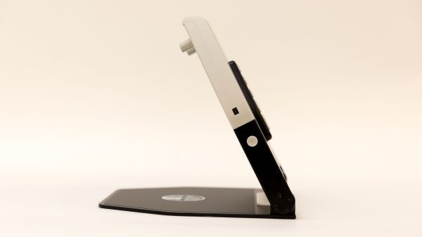 A side view of an opened Neptune without the monitor attached. The device is white and black with a black metal base, and there is a white power button on the side.