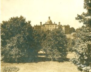 The KSB building appears behind some trees in a dated photographed, the hue is tinted a yellow color that shows its age.
