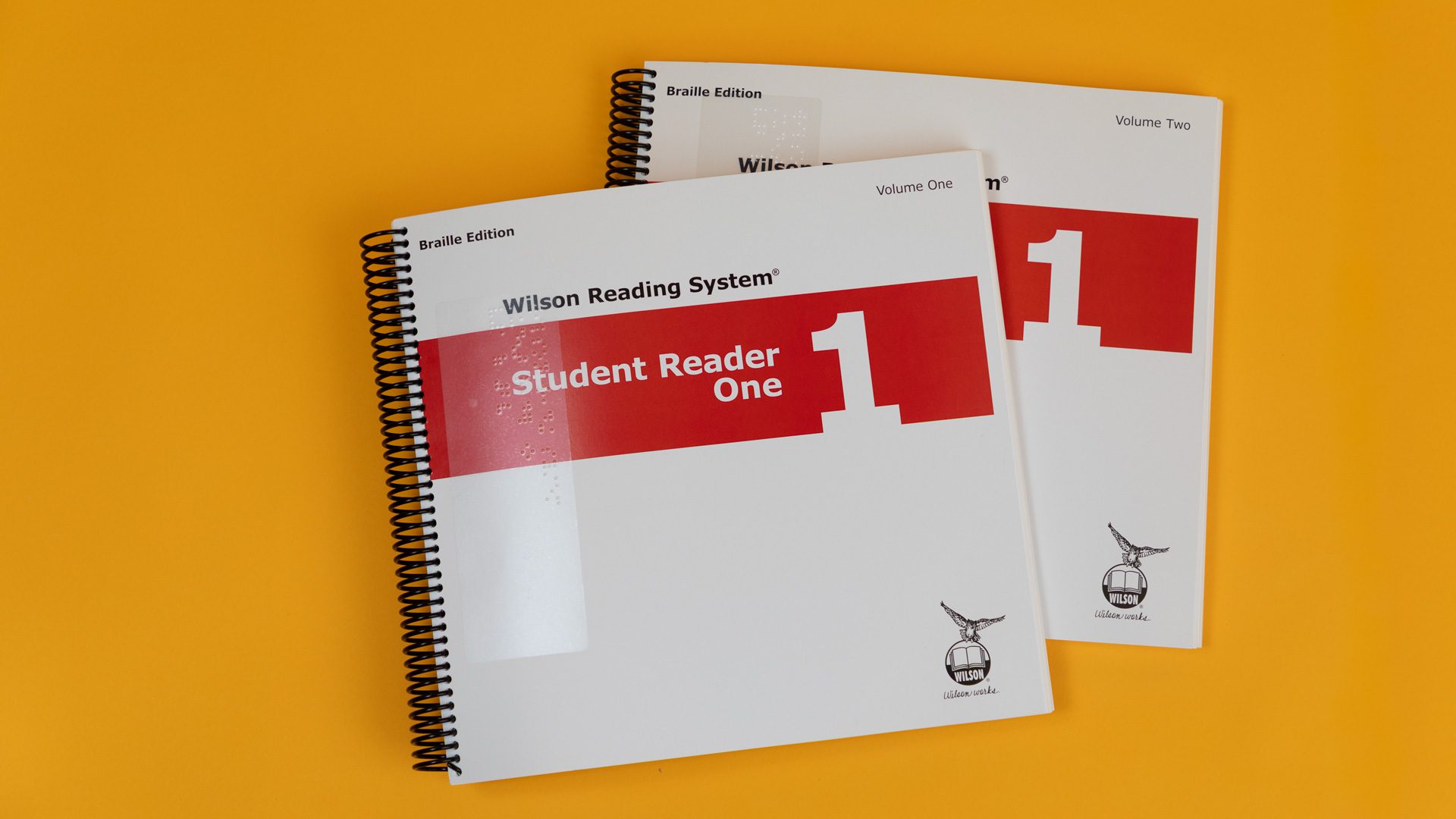WRS-Braille-Student-Reader-1_4Z9A1204-web Volumes 1 and 2 of the braille student reader 1 with a red stripe across both covers.