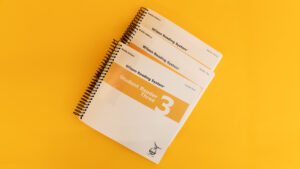 Volumes 1, 2, and 3 of the braille student reader 3 with a yellow stripe across all three covers.