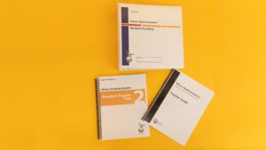 Wilson Reading System IV large print step two on a yellow background, including the large print student reader 2, the large print teacher guide, and the large print student portfolio.