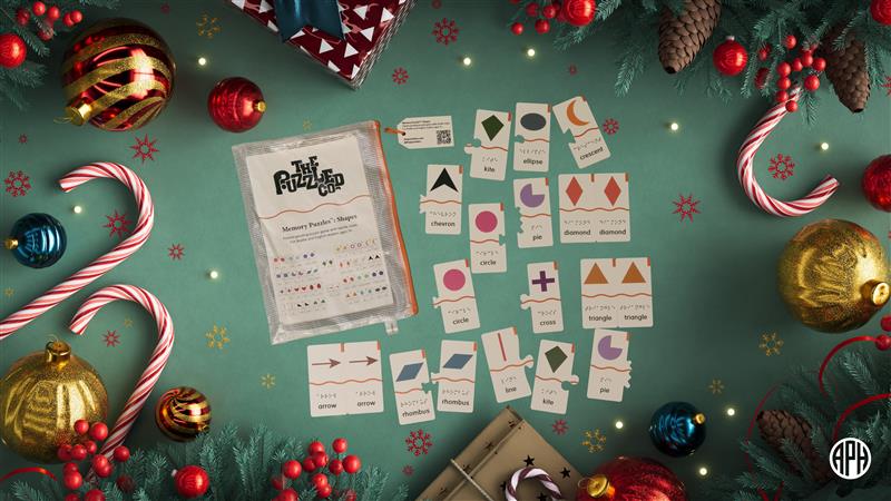 Memory Puzzles shapes lay in the center of a green backdrop, surrounded by holiday decorations like ornaments, bells, and candy canes.