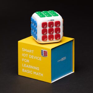 Creacube with the red buttons facing forward sitting on top of the yellow and blue box.