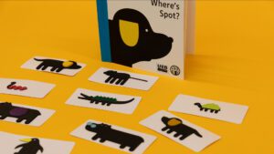 A variety of animal cards with tactile elements arranged on a yellow background in front of the Where's Spot? storybook.