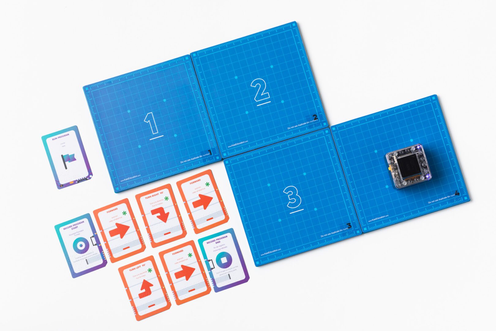 The KaiBot magnetic tiles arranged into a path next to coding cards.