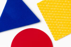 A close-up of three shapes two-dimensional shape manipulatives with different colors and textures.